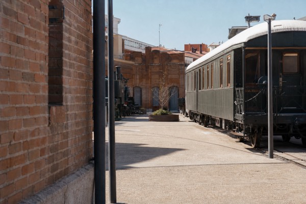 Historic steam locomotive standing on rails beneath an iron and glass station roof